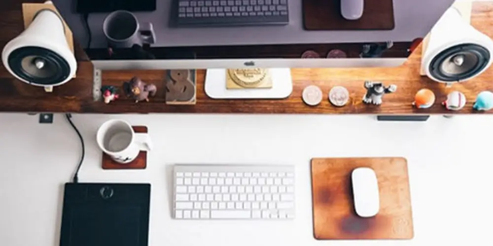 desk image with desktop, mouse, keyboard, empty coffee mug and speakers