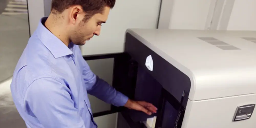 man reaching to take print out of 3d printer