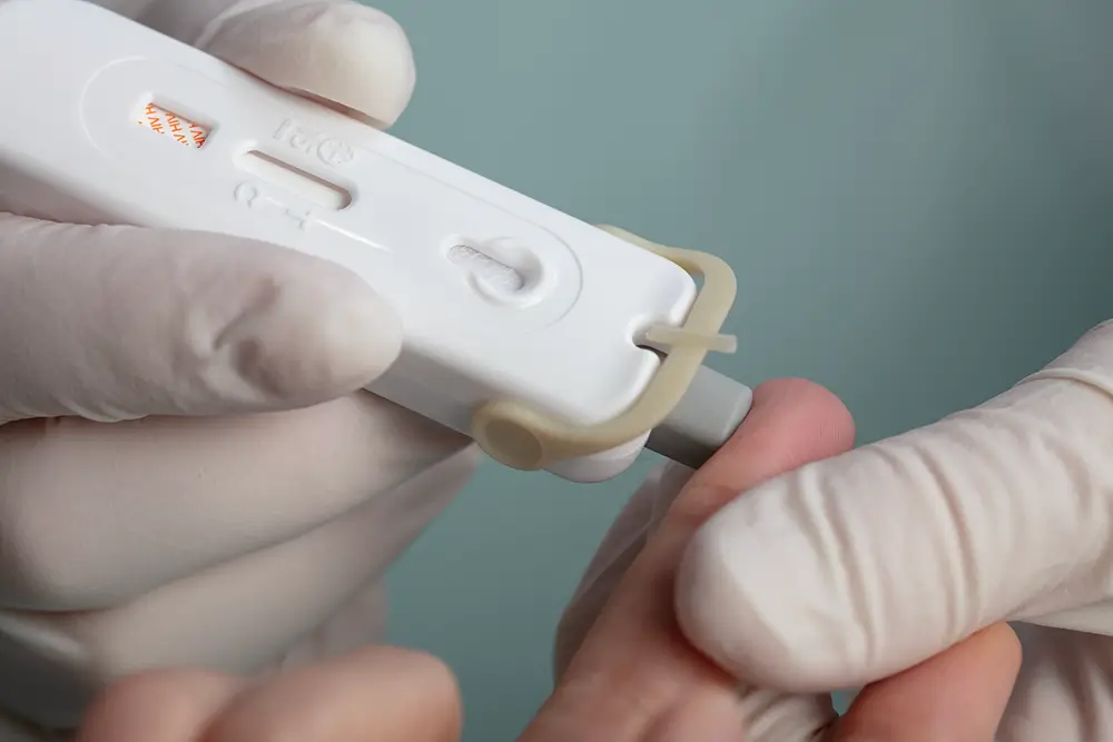 Atomo HIV Rapid Test being applied onto a finger