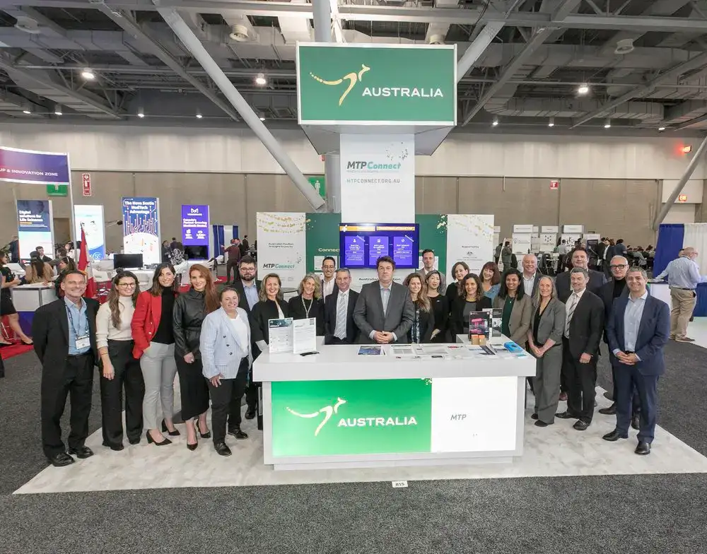 group of people stand in front of the mtp connect signage for the medtech conference in boston in 2022