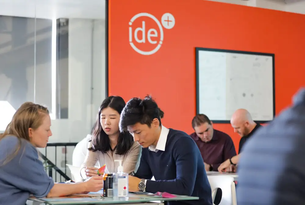 Ide employees sit and discuss together at a table