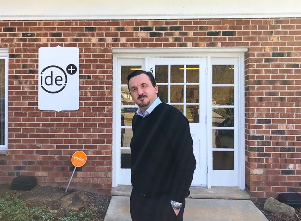 Richard Sokolov standing outside of a building with IDE logo